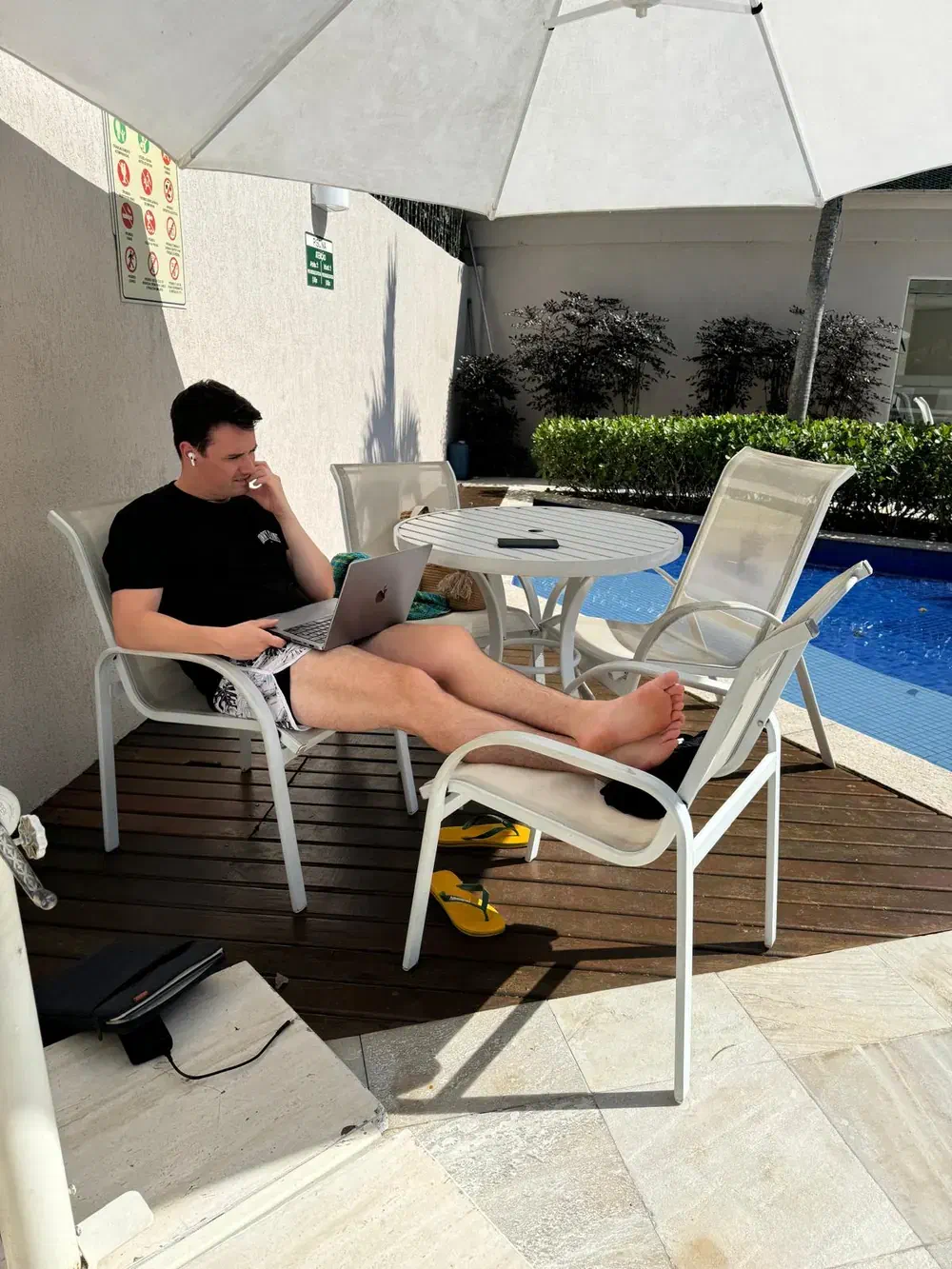 Christof Jori arbeitet mit einem Laptop neben einem Swimmingpool Christof Jori arbeitet mit einem Laptop neben einem Swimmingpool